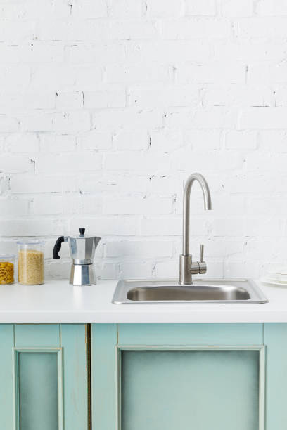 istock modern white and turquoise kitchen interior with kitchenware and sink near brick wall 1196199332