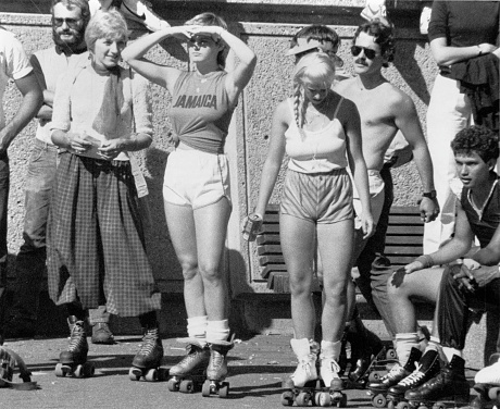 This image is of a group of rollerskaters on Copley Square Plaza in the mid 1980s. Rollerskaters would assemble on the plaza on Weekends in the Summer at that time.