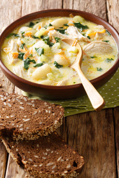 istock Thick cream soup with gnocchi, chicken, spinach and vegetables close-up in a bowl. vertical 1196210773