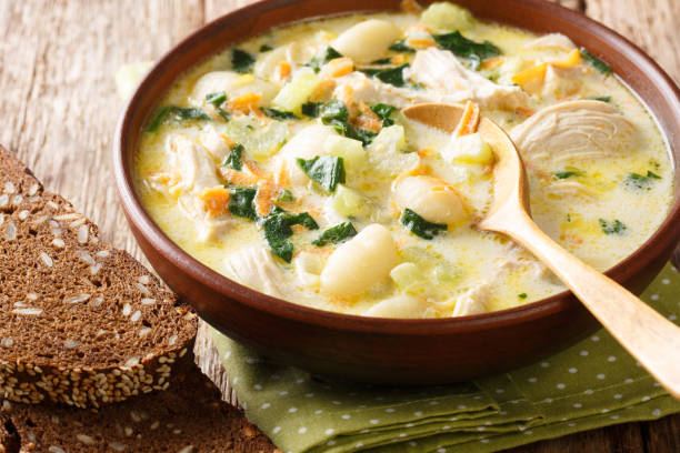 cream soup with gnocchi, chicken and spinach served with bread close-up in a bowl. Horizontal cream soup with gnocchi, chicken and spinach served with bread close-up in a bowl on the table. Horizontal dumpling stock pictures, royalty-free photos & images