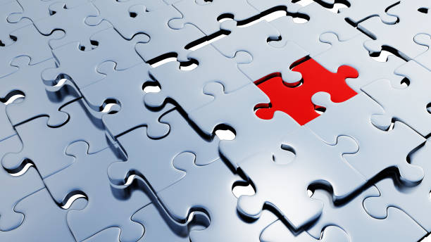 istock Many silver puzzle pieces placed soon with a large red piece between them 1196212427