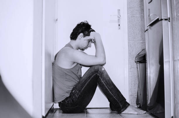 I will never love again.Adolescence male having problems Young depressed and anxious man sitting on the floor at home,leaning on hands and wall.Thoughtful heart broken man sad gay stock pictures, royalty-free photos & images