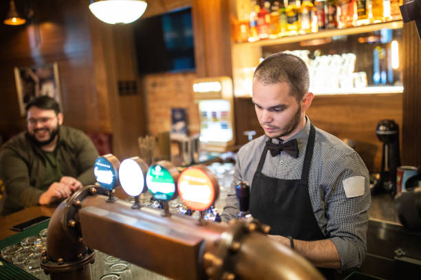 istock Bartender pouring beer from beer tap in a bar 1196214193