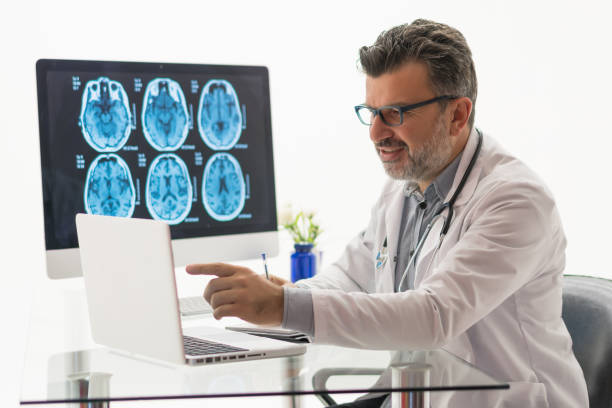 istock Doctor working on desk with laptop 1196223367