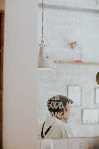 Reflection between Barista looking to customer and various of menu coffee, menu, choice, cafe, coffee shop, one person, standing, hipster person, barista, working, small business, vertical mirror writing stock pictures, royalty-free photos & images