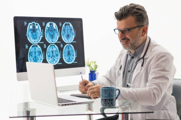 istock Doctor working on desk with laptop 1196223847