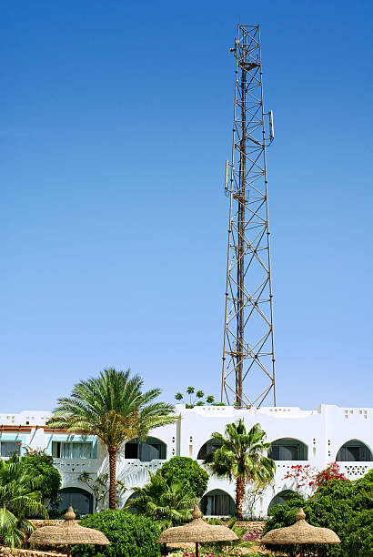 communication tower with cellular antennas above tropical resort stock photo