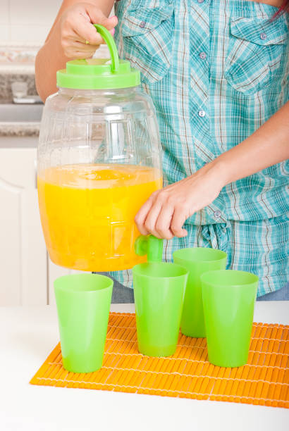istock Pitcher for juice dispenser and four plastic cups. 1196227129
