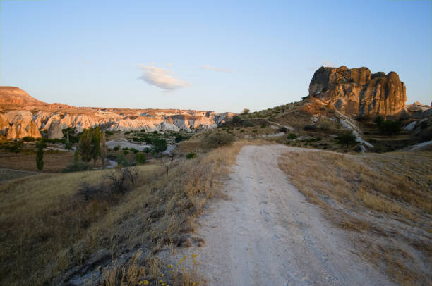 camino de tierra en el paisaje de montaña desértico en capadocia - goreme rural scene sandstone color image fotografías e imágenes de stock