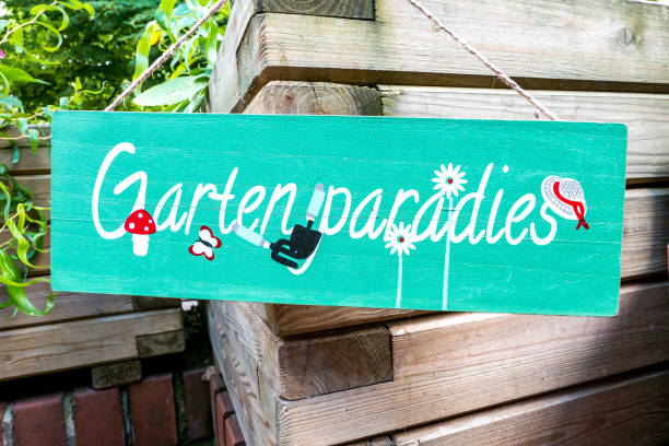 Berlin, Berlin/Germany - 16.07.2019: A green or turquoise wooden sign with the inscription Garden Paradise and funny pictograms