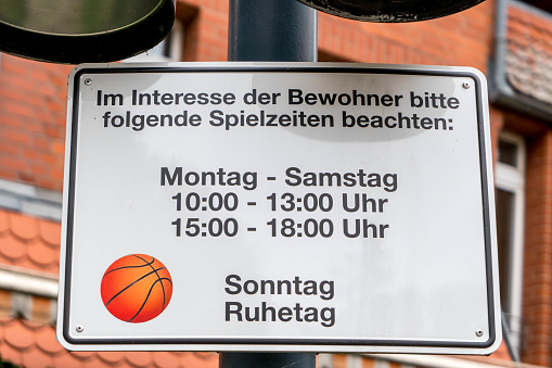 Berlin, Berlin/Germany - 15.07.2019: A sign indicating that children may only play between 10.00 and 13.00 and 15.00 to 18.00 o'clock, Sunday day off