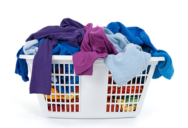 Colorful clothes in laundry basket. Blue, indigo, purple. stock photo