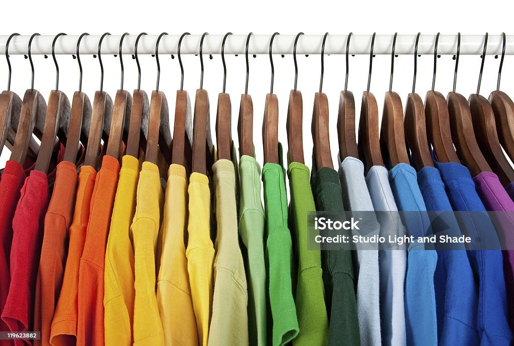 Rainbow colors, clothes on wooden hangers Rainbow colors. Choice of casual clothes on wooden hangers, isolated on white. Clothes Rack Stock Photo