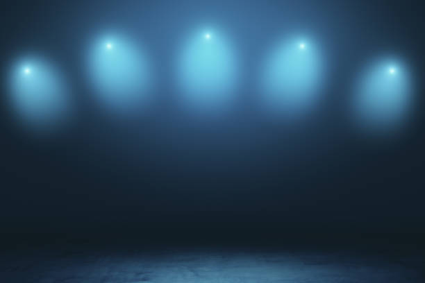 istock Abstract empty stage in dark hall with blurry spotlights and dark concrete floor. 1196239514