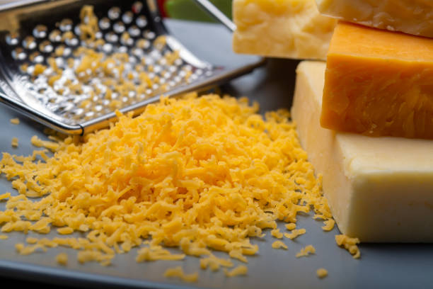 istock Cheese collection, matured and orange original British cheddar cheese in blocks and grated served on grey plate 1196239903