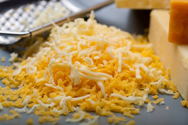 istock Cheese collection, matured and orange original British cheddar cheese in blocks and grated served on grey plate 1196239912