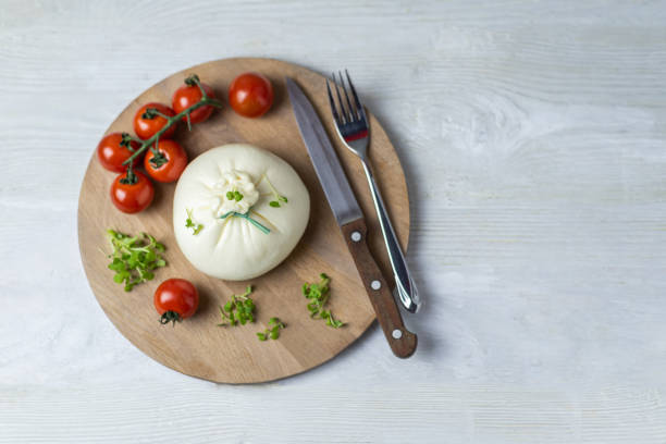 istock Burrata cheese on a round wooden tray 1196241905