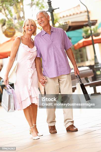 Pareja Senior Disfrutando De Viaje De Compras Foto de stock y más banco de imágenes de 60-69 años - 60-69 años, Adulto, Agarrar