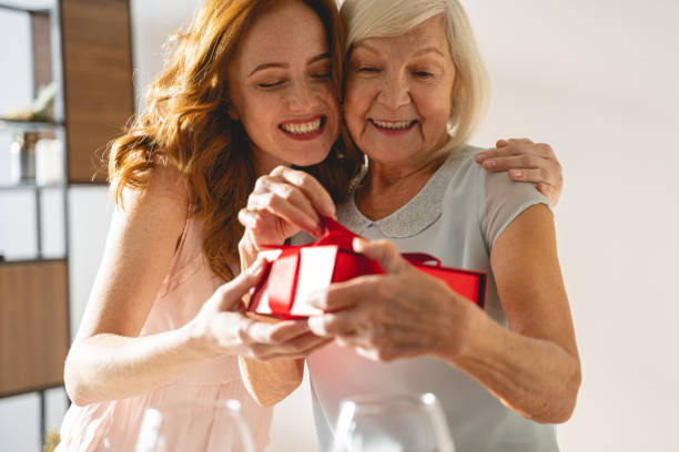 Positive delighted girl caressing her kind granny