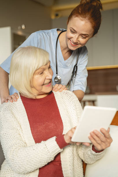 istock Positive delighted senior woman pointing at her tablet 1196243748