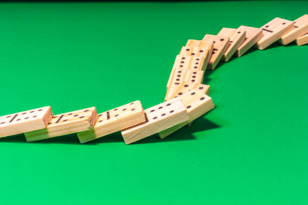 renversé domino show avec des dominos en bois sur le vert - dobs photos et images de collection