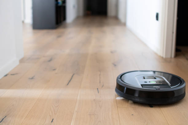 Blurred background of interior apartment with a robot vacuum cleaner stock photo