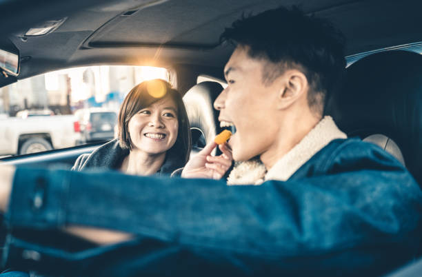 istock Asian couple snacking in the car 1196245634