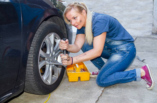 istock Woman Fixing the Car Wheel 1196247776