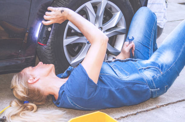 istock Woman Fixing the Car Wheel 1196249033
