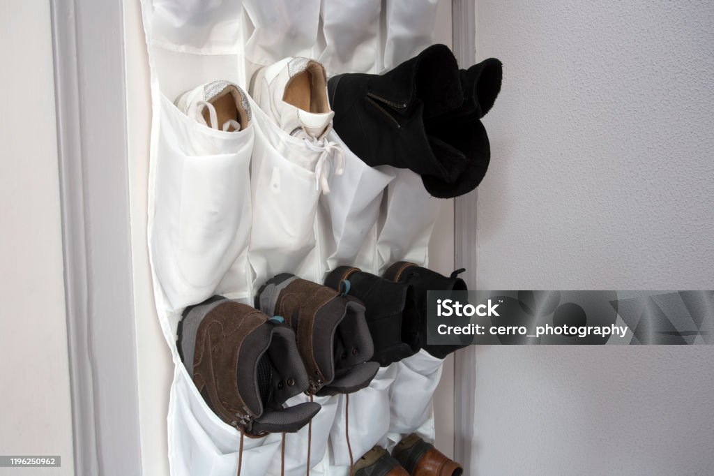 Shoe rack hanging on a wooden door, storage for shoes Shoe rack hanging on a wooden door, storage for shoes close-up Shoe Stock Photo