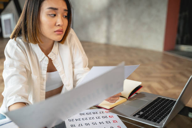 istock Asian charming woman working with papers and laptop 1196251080