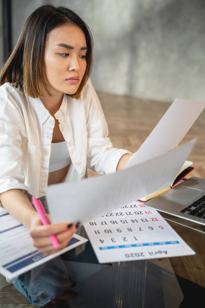 istock Asian young woman working with papers indoors 1196251084