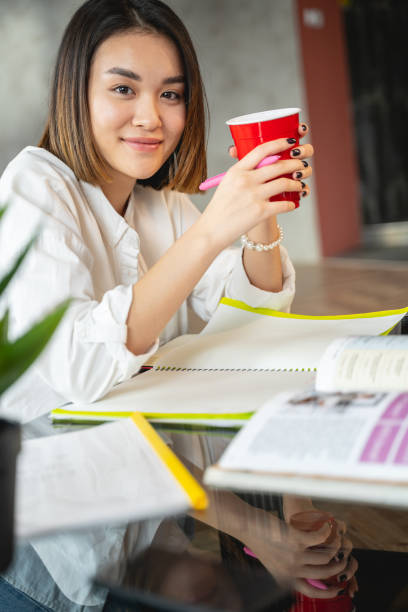 istock Asian young woman is drinking tea indoors 1196251093