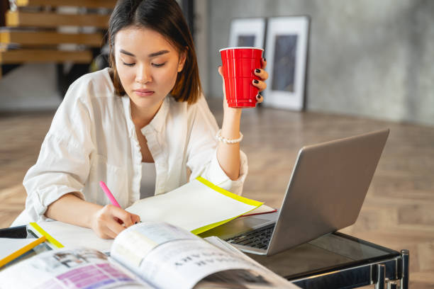 istock Asian young woman making notes in office 1196251099
