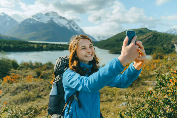 Woman with backpack making selfie near the  lake in  Torres del Paine National Park Young Caucasian woman with backpack making selfie near the  lake in  Torres del Paine National Park chile tourist stock pictures, royalty-free photos & images