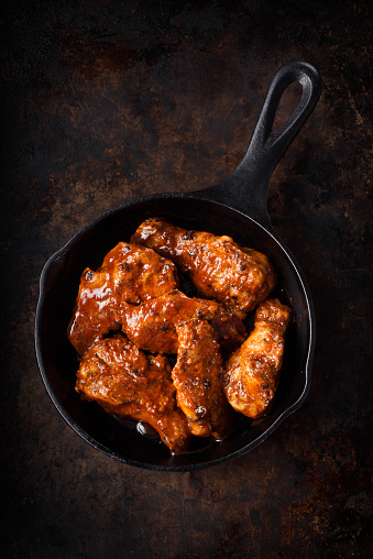 Juicy and spicy chicken wings in a black cast iron skillet