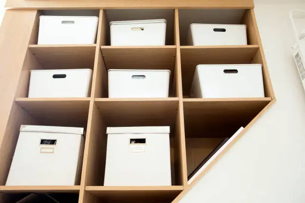 Photo of Modern interior white boxes in wooden shelfs for storage, modern interior clean up