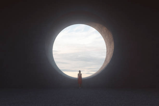 istock Lonely young woman looking through concrete window 1196259278