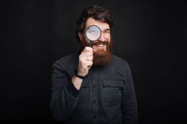 虫眼鏡を持つハンサムなひげの男の肖像画 - magnifying glass lens holding europe ストックフォトと画像