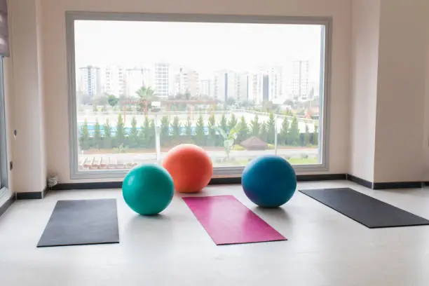 Photo of Colorful pilates balls and exercise sports equipments indoor concept image background. Gym interior.