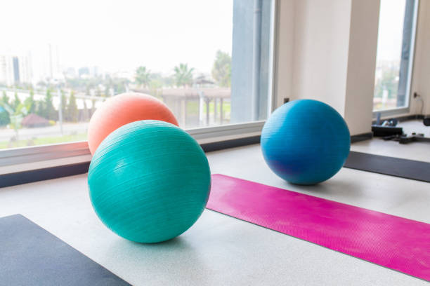 palle pilates colorate e attrezzature sportive per esercizi sfondo immagine concetto interno. interni da palestra. - yoga ball foto e immagini stock