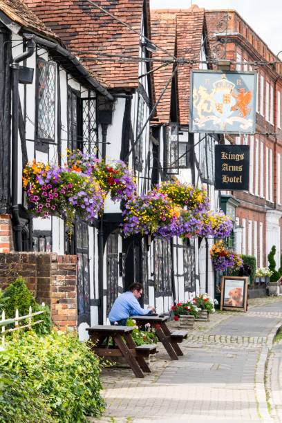 Kings Arms Hotel in the old town Amersham, England - August 22nd 2019: A man sits outside the Kings Arms Hotel in the old town. The hotel dates from the 15th century. amersham stock pictures, royalty-free photos & images