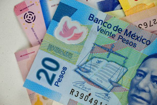 istock Many mexican pesos bills spread randomly over a flat surface 1196274195