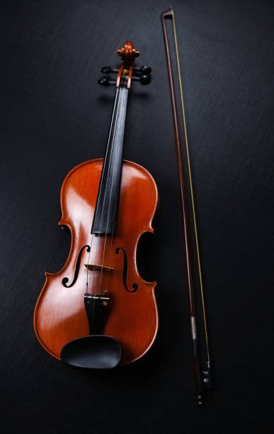 istock The wooden violin and bow put on black canvas background 1196277000