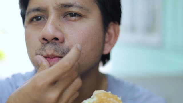 Close up young asian man eating hamburger