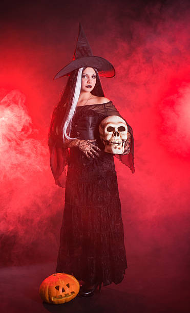 istock Halloween witch with a skull and pumpkin 119628745