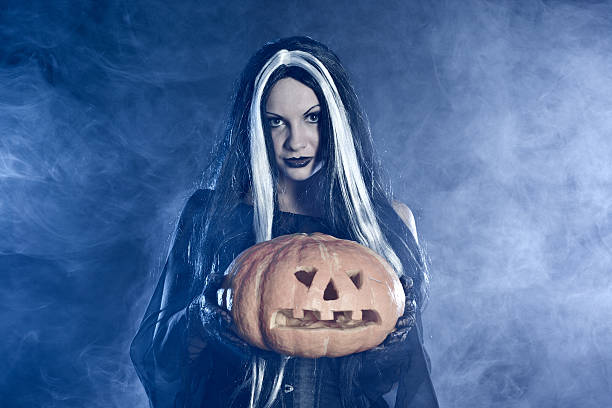 istock Portrait Halloween witch with a pumpkin 119628758