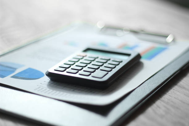 istock close up. blurred image of pen and calculator on desktop 1196288816