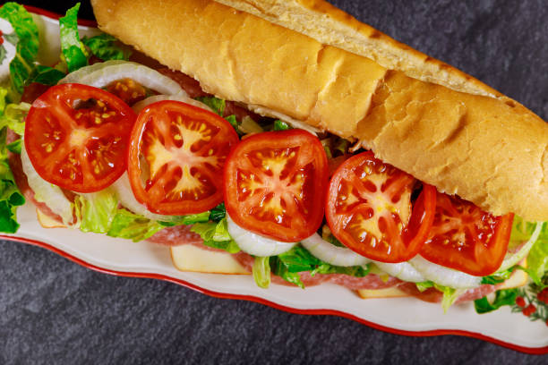 sándwich con salami, queso y verduras. - sandwich submarine delicatessen salami fotografías e imágenes de stock