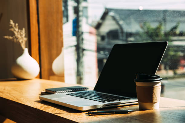 istock Laptop with paper coffee mugs,pen on table. 1196296669